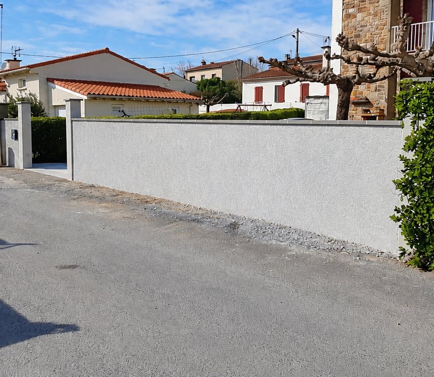 Après : haie remplacée par un mur de clôture enduit