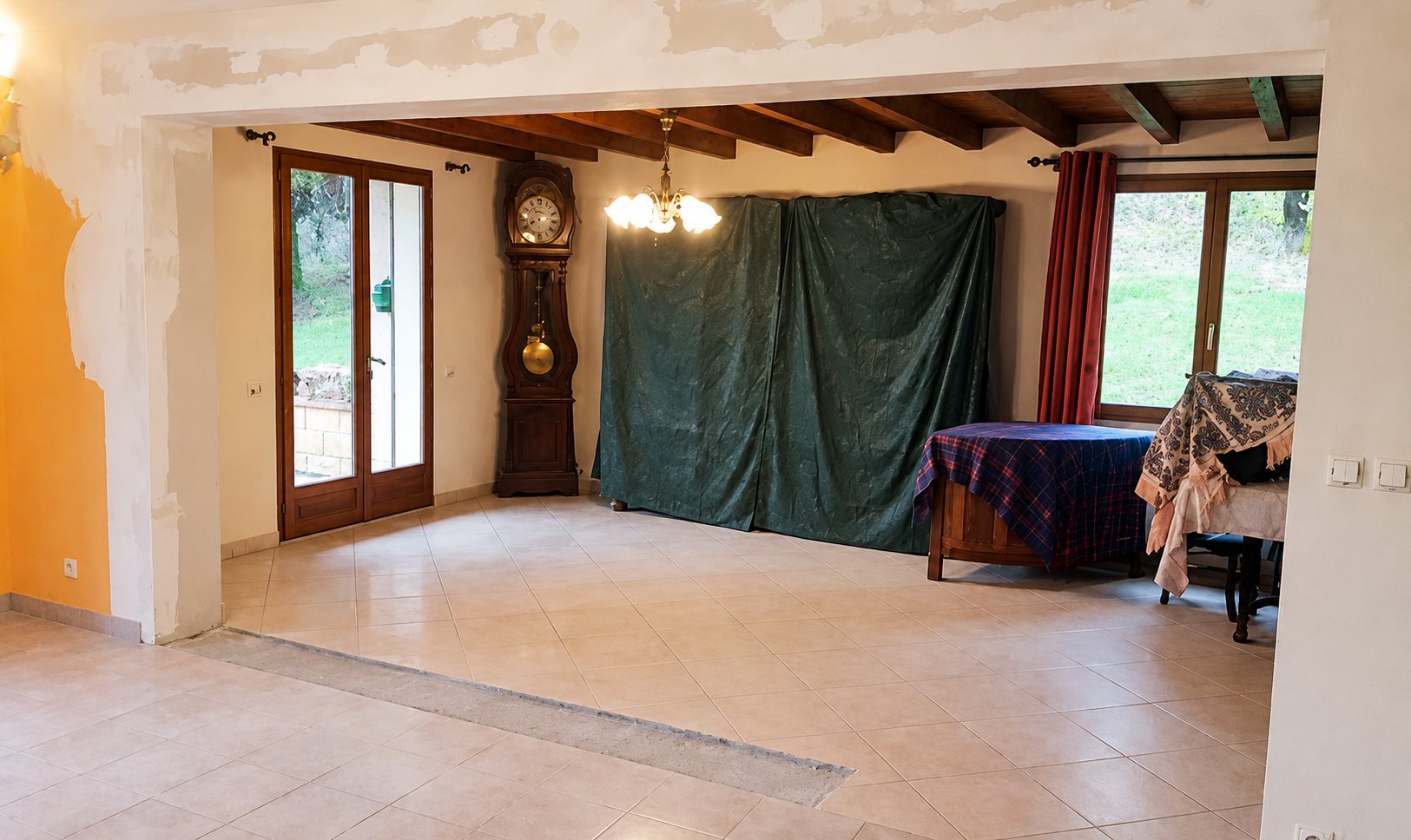 Pièce à vivre en rénovation avec carrelage clair et horloge comtoise