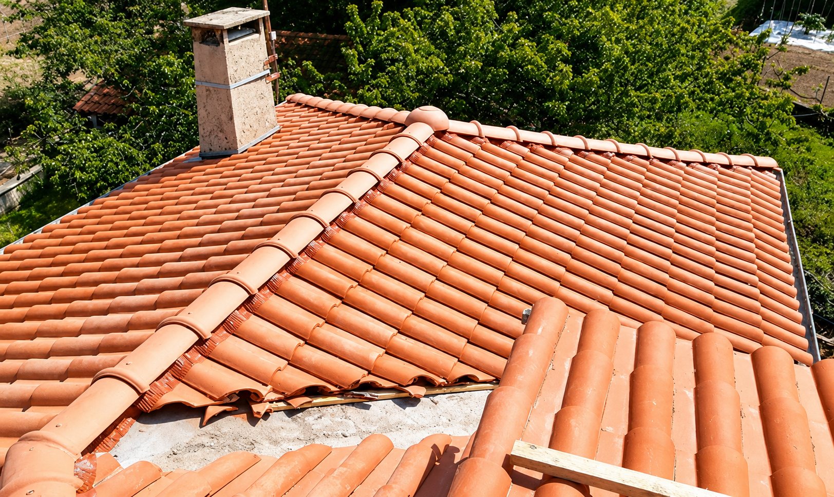 Toiture en tuiles canal oranges avec cheminée, après rénovation